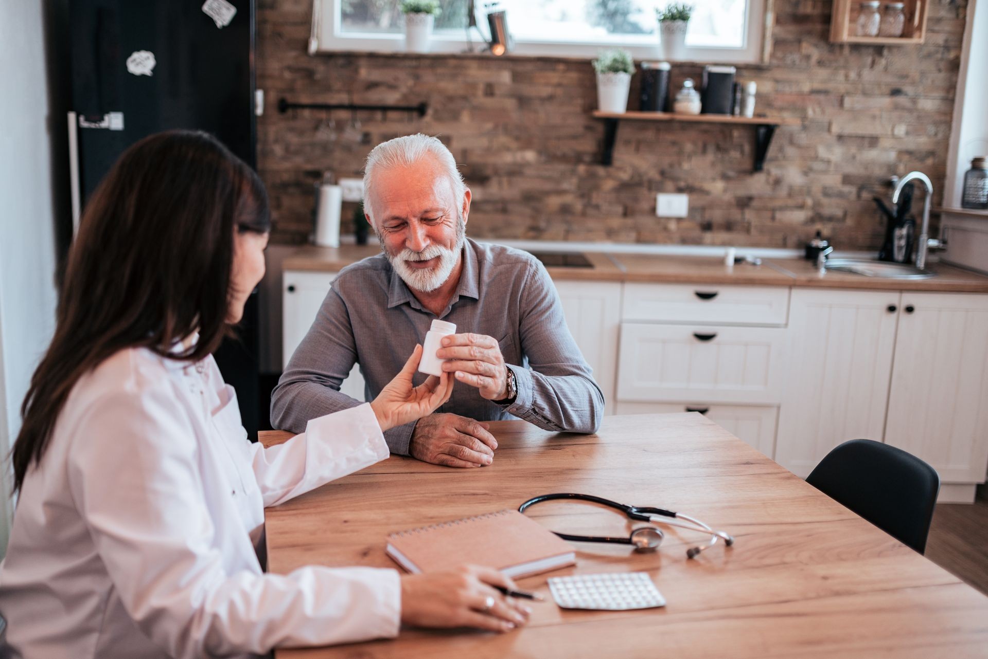 Senior man is visited by his doctor or caregiver at home.